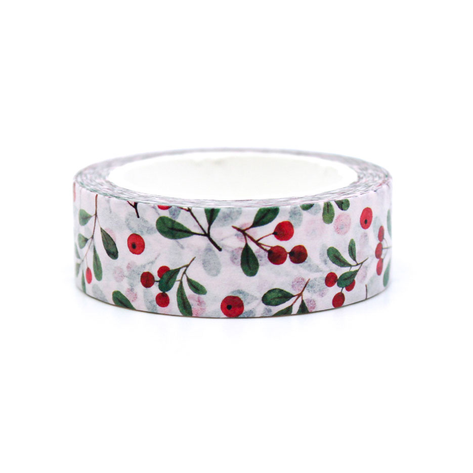 Close-up of berry and leaf patterned washi tape used to decorate an envelope on red background.
