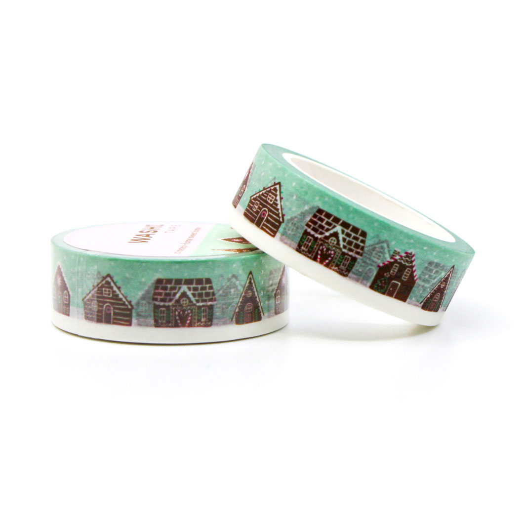 Festive gingerbread house washi tape unrolled on pink background — perfect for holiday paper crafts.