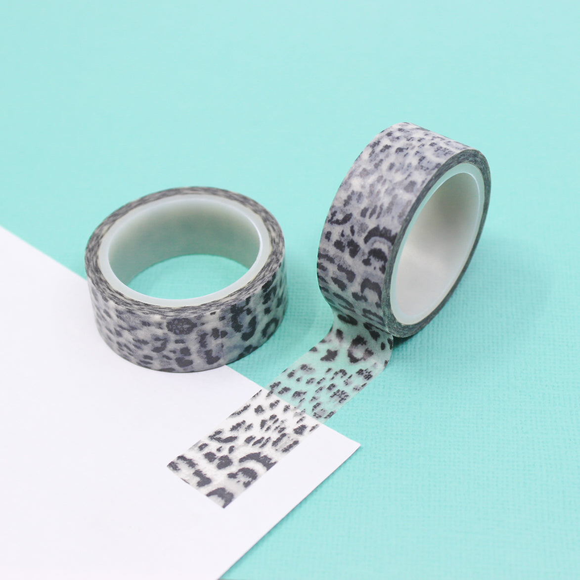 A close-up photo of snow leopard pattern washi tape. The tape features a white background with intricate black spots resembling the distinctive markings of a snow leopard. The pattern exudes elegance and captures the beauty of this majestic big cat. This tape is sold exclusively at BBB Supplies Craft Shop.