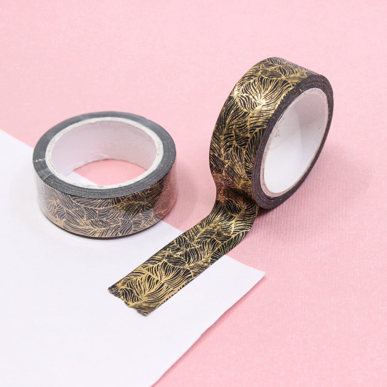 Decorative washi tape featuring gold foil feathers on a black base