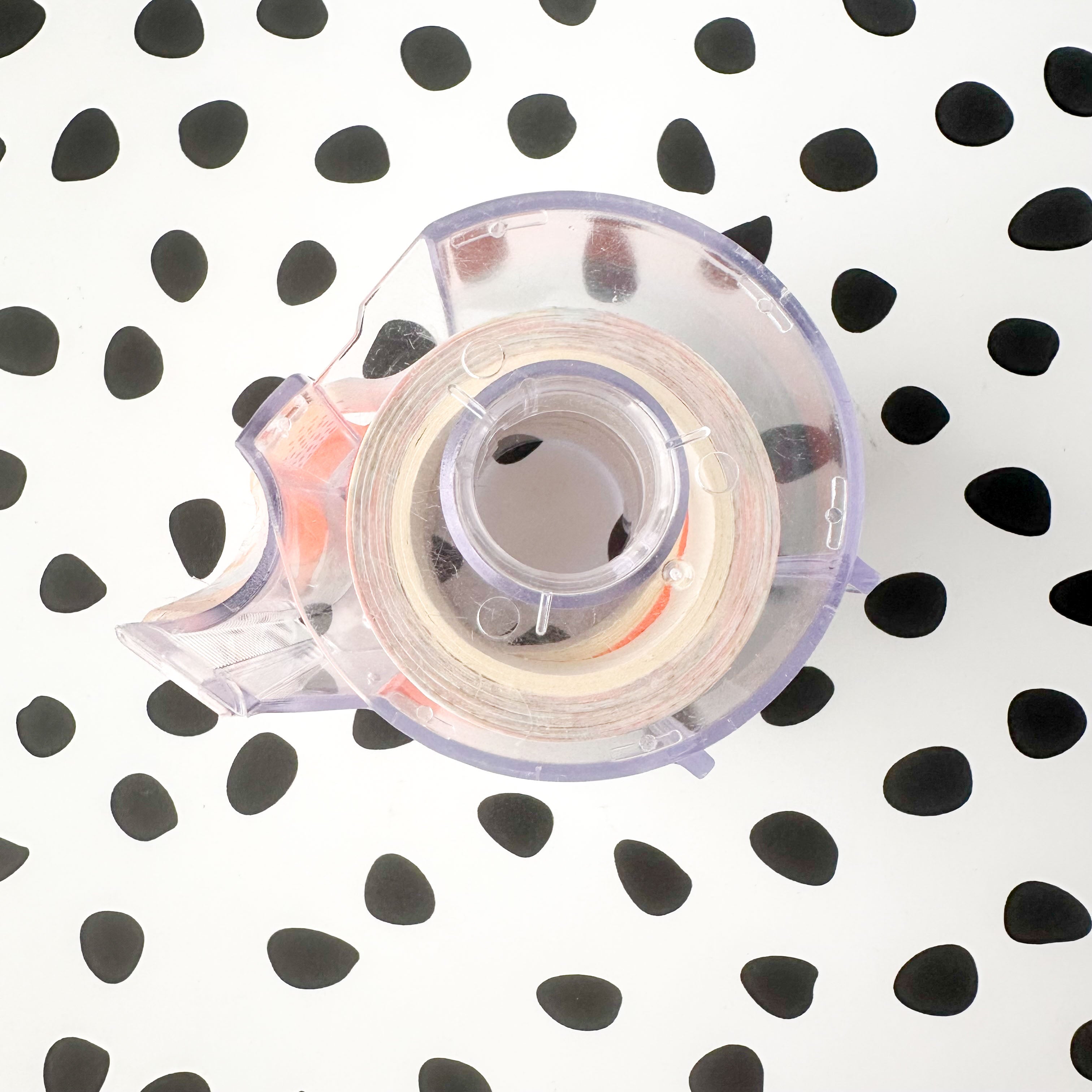 Compact plastic washi tape organizer and cutter displayed with journaling supplies