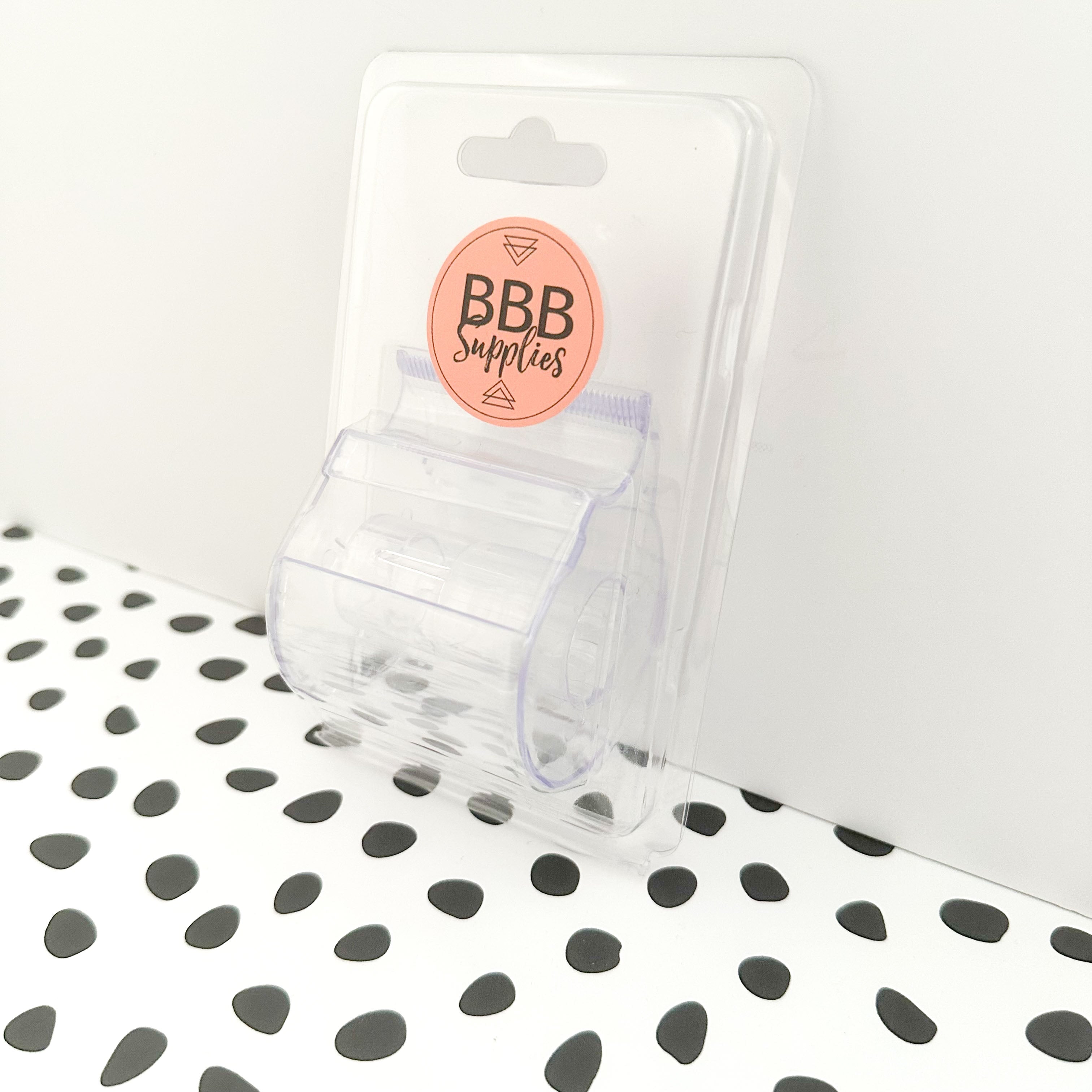 Side view of transparent washi tape dispenser loaded with patterned tapes