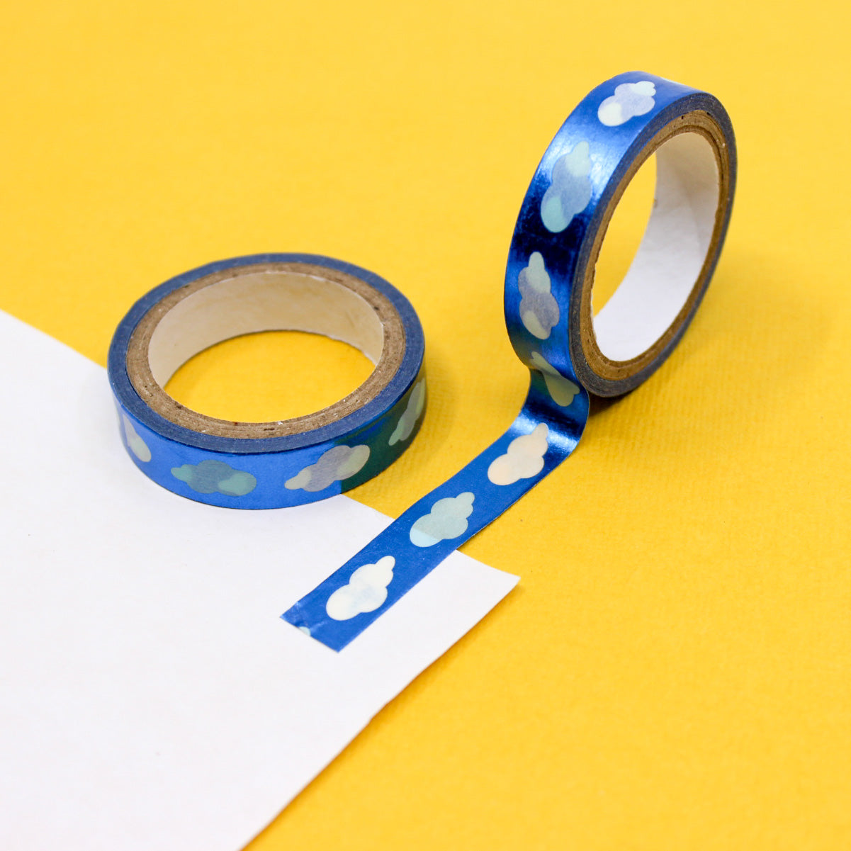Blue washi tape with shimmering foil clouds, ideal for decorating planners, scrapbooks, and craft projects.