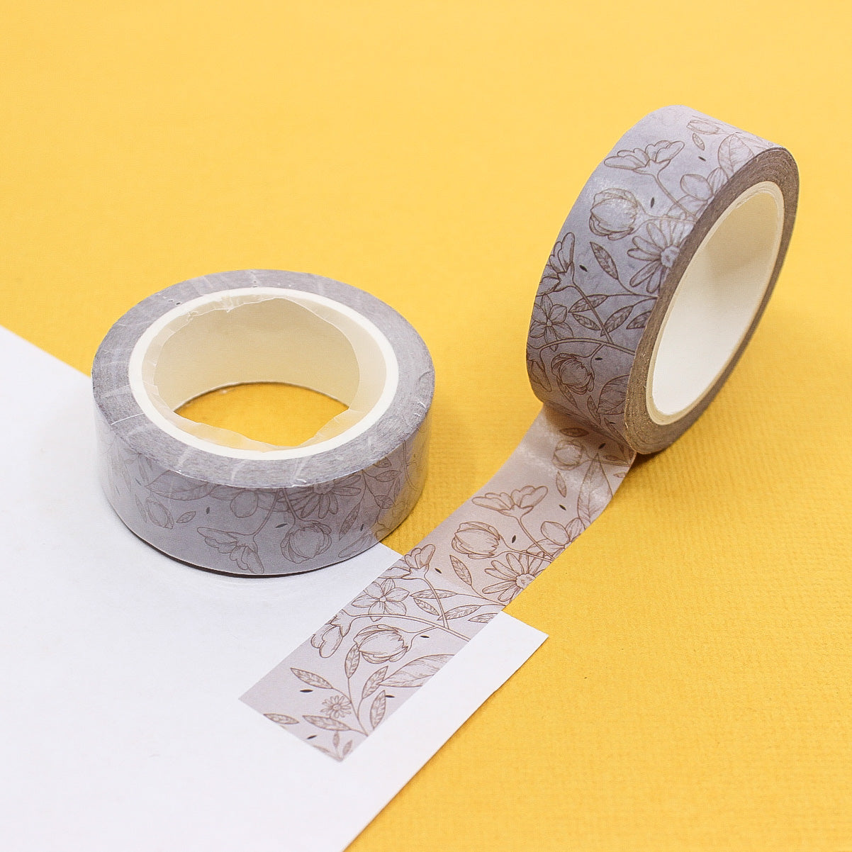 Add a subtle floral touch to your crafts with this elegant neutral linea floral washi tape. Perfect for adding a sophisticated accent to your journals, scrapbooks, and other projects. This tape is sold at BBB Supplies Craft Shop.