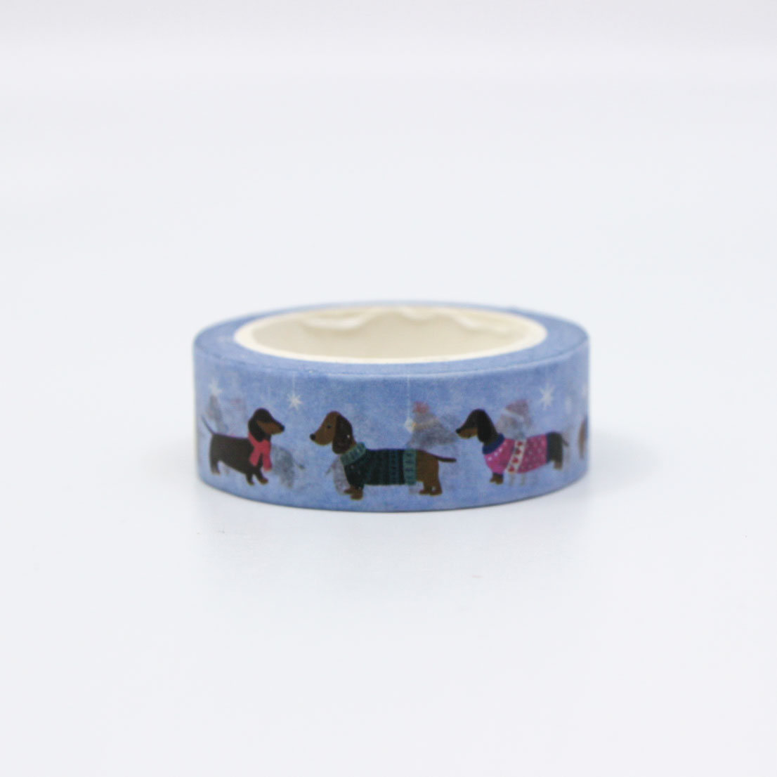 Holiday washi tape roll with cozy pups wearing winter clothes on a blue background.