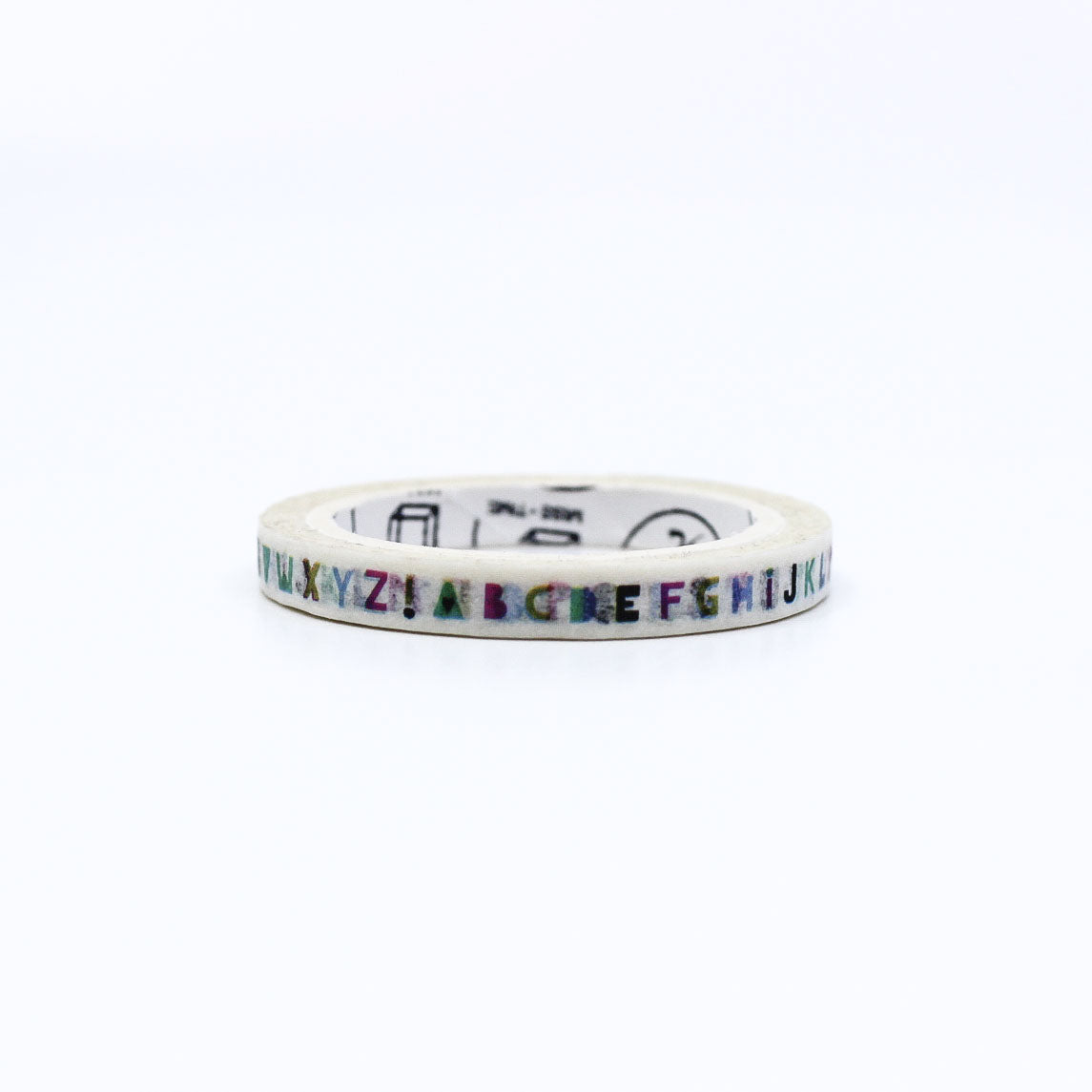 Alphabet letter washi tape next to its original packaging on a yellow background.