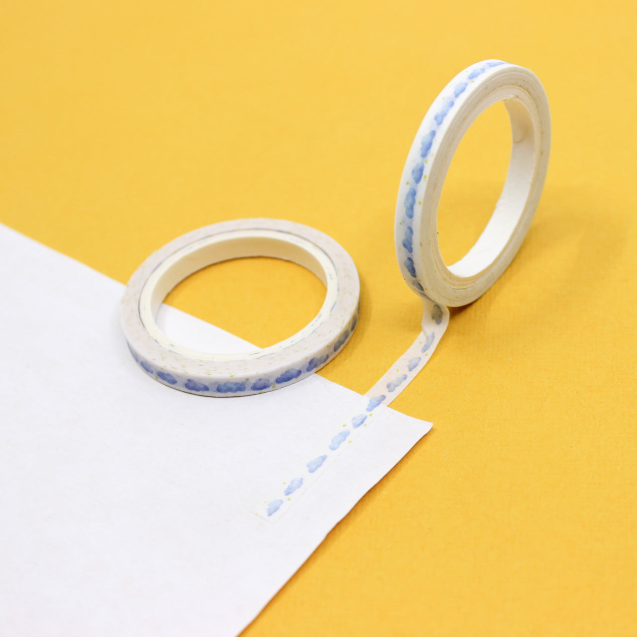 Decorative cloud washi tape roll with tiny yellow star accents unrolled for display.