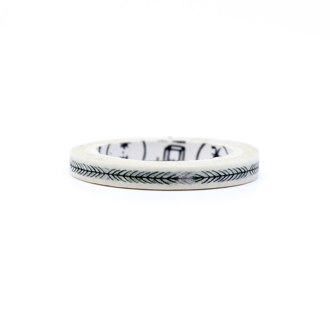 Roll of botanical pattern washi tape standing upright with a strip applied to white paper.