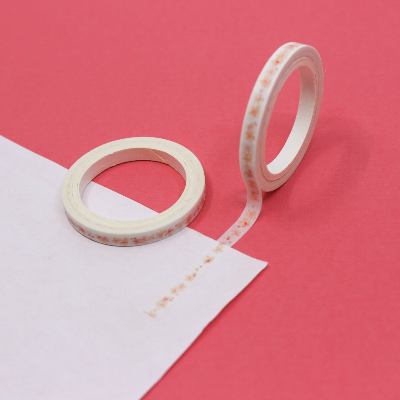 Add a touch of floral elegance to your projects with our Narrow Pink Flowers Border Washi Tape, adorned with delicate pink flower patterns. Ideal for bringing a hint of natural beauty to your crafts. This tape is sold at BBB Supplies Craft Shop.