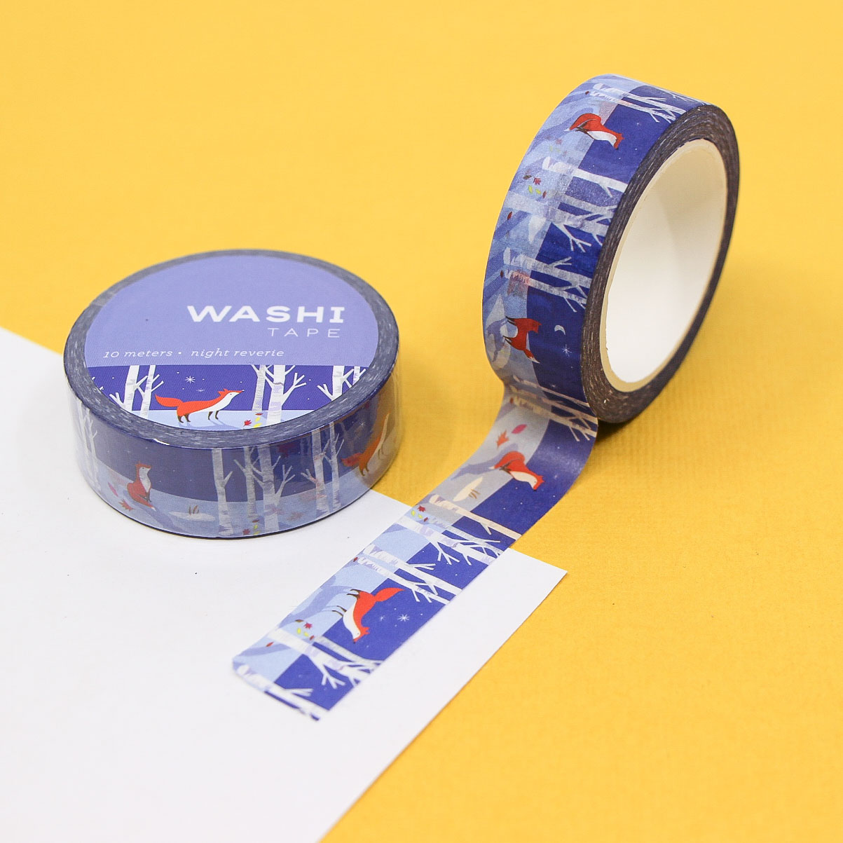 Night Reverie Washi Tape featuring red foxes in a snowy forest under a starry blue sky on a yellow background