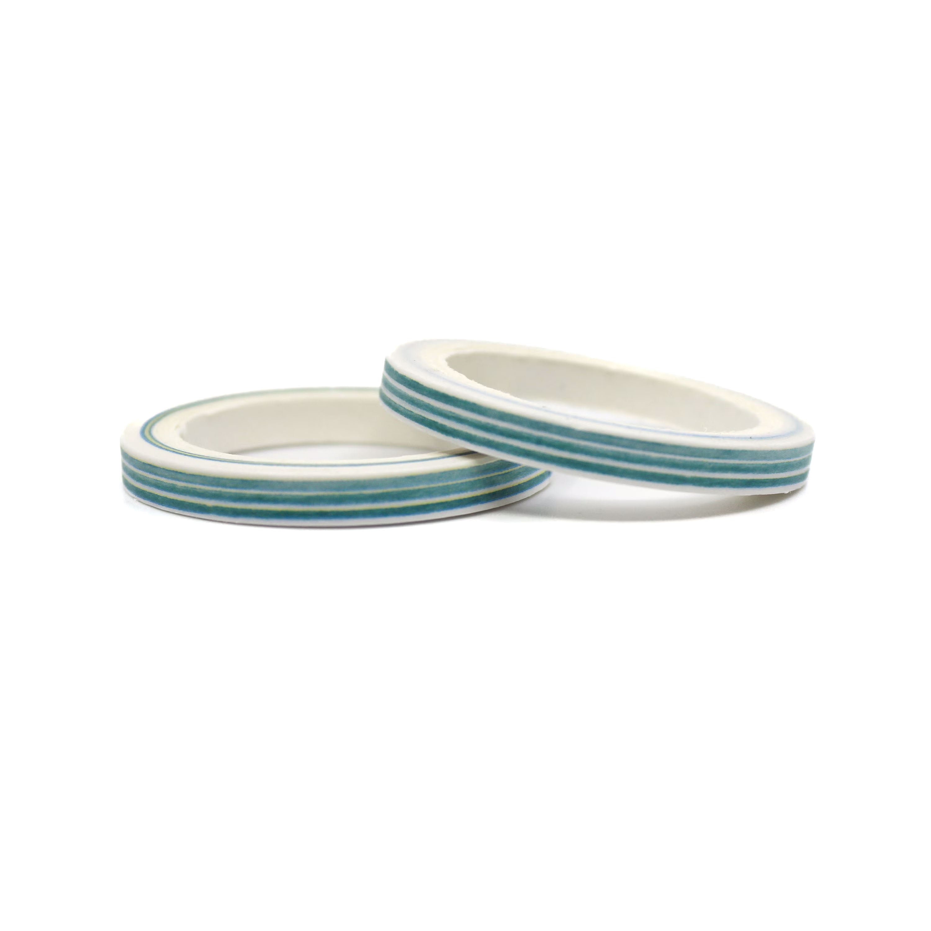 Close-up of two thin planner tape with green stripes laying on table