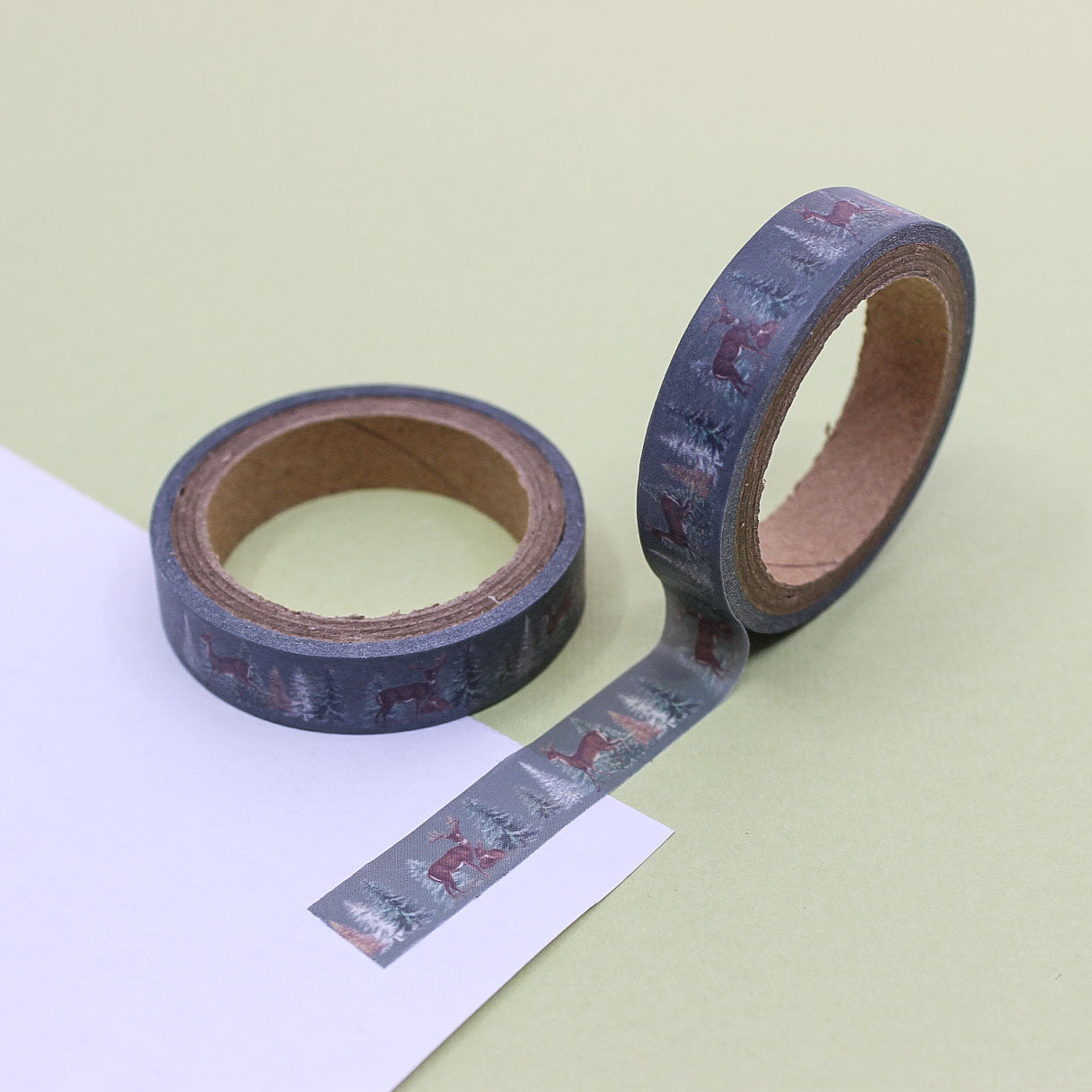 Holiday planner washi tape with woodland forest scene displayed on red background.