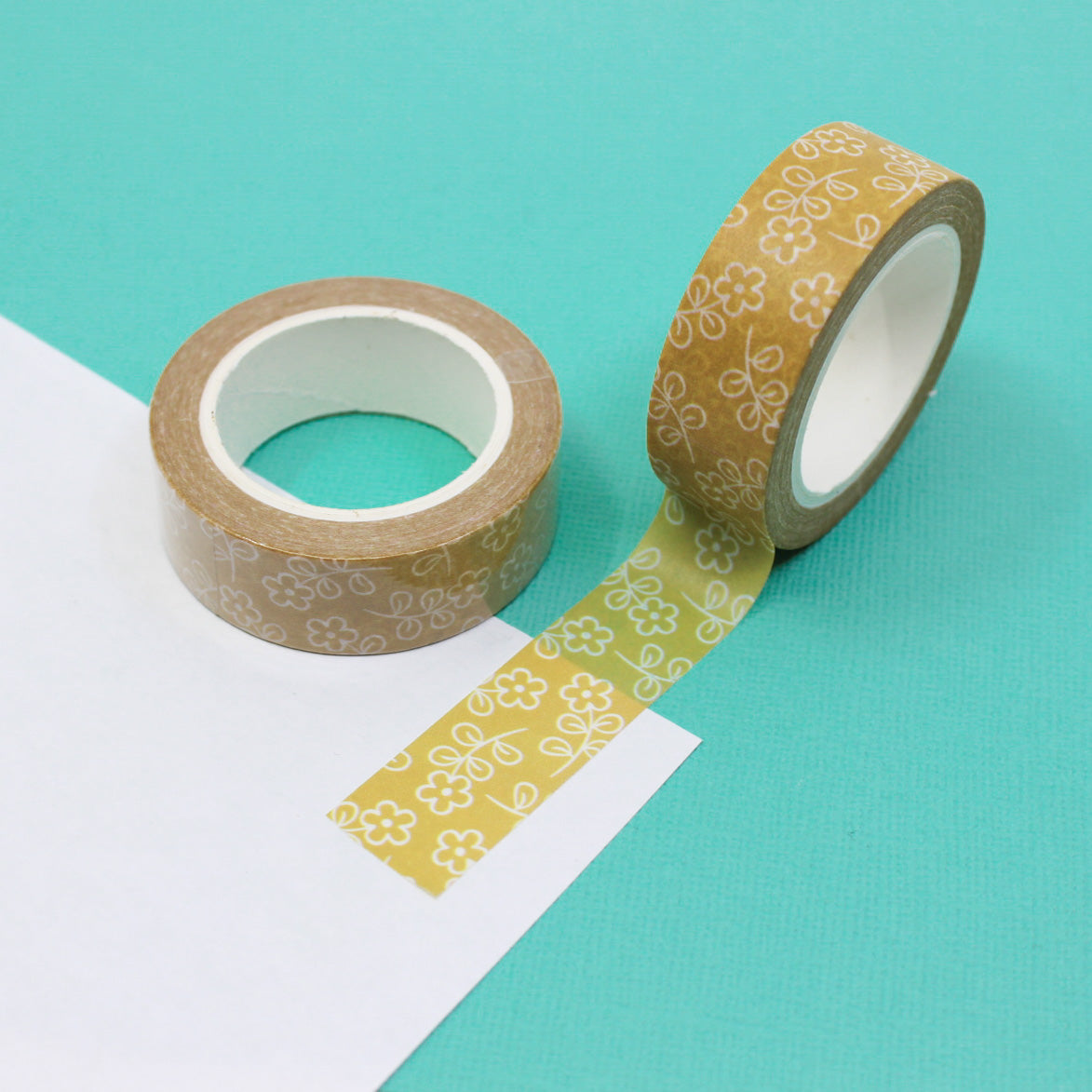 This vibrant washi tape features a pattern of yellow daisy flowers, perfect for adding a cheerful touch to your crafts and projects. This tape is sold at BBB Supplies Craft Shop.