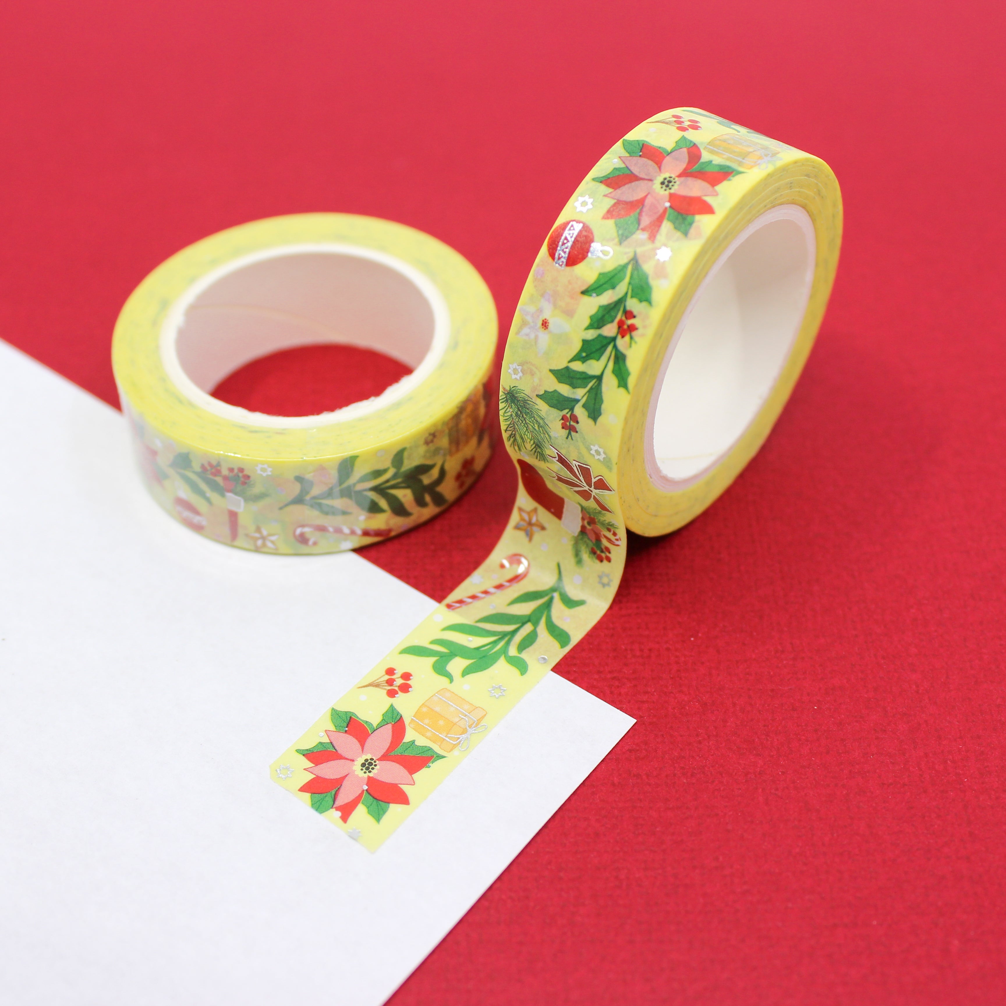 This is a warm yellow Holiday tape with silver foil accents that includes symbols of Stockings, Candy Canes, Poinsettias, and holiday foliage.