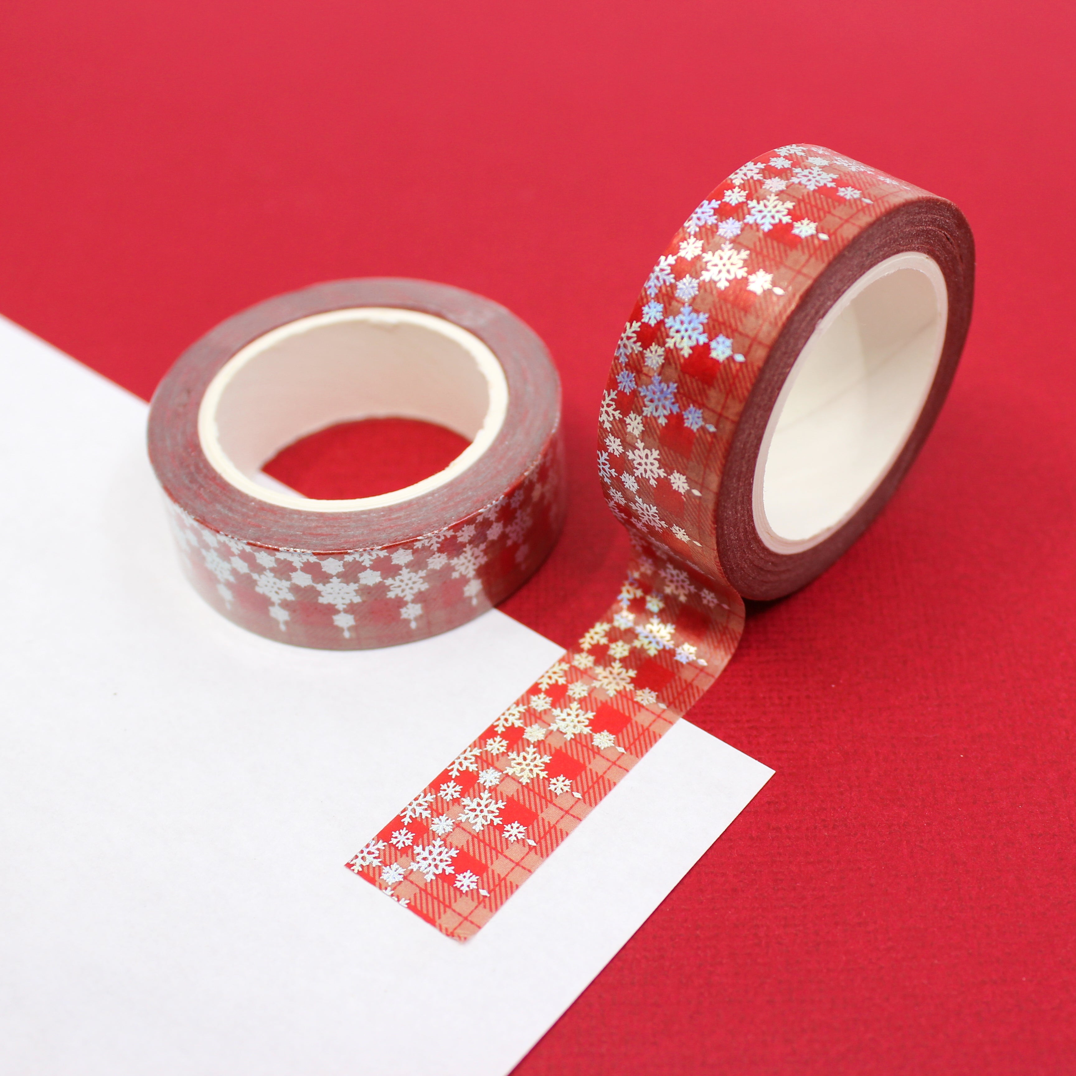 This is a beautiful silver foil snowflake pattern washi tape on a traditional Holiday red plaid  Background from BBB Supplies Craft Shop