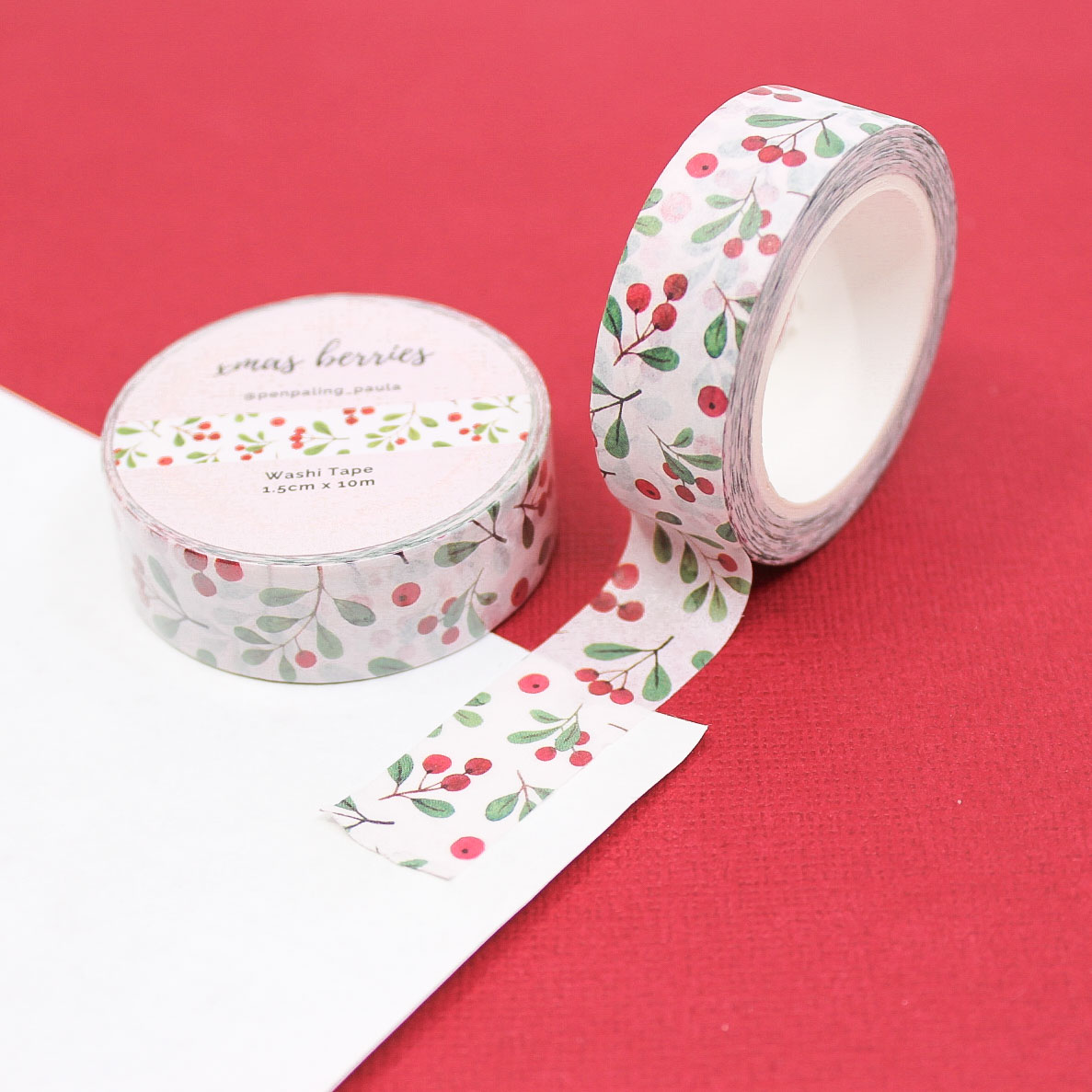 Xmas Berries Washi Tape roll with watercolor red berries and green leaves on blush background.