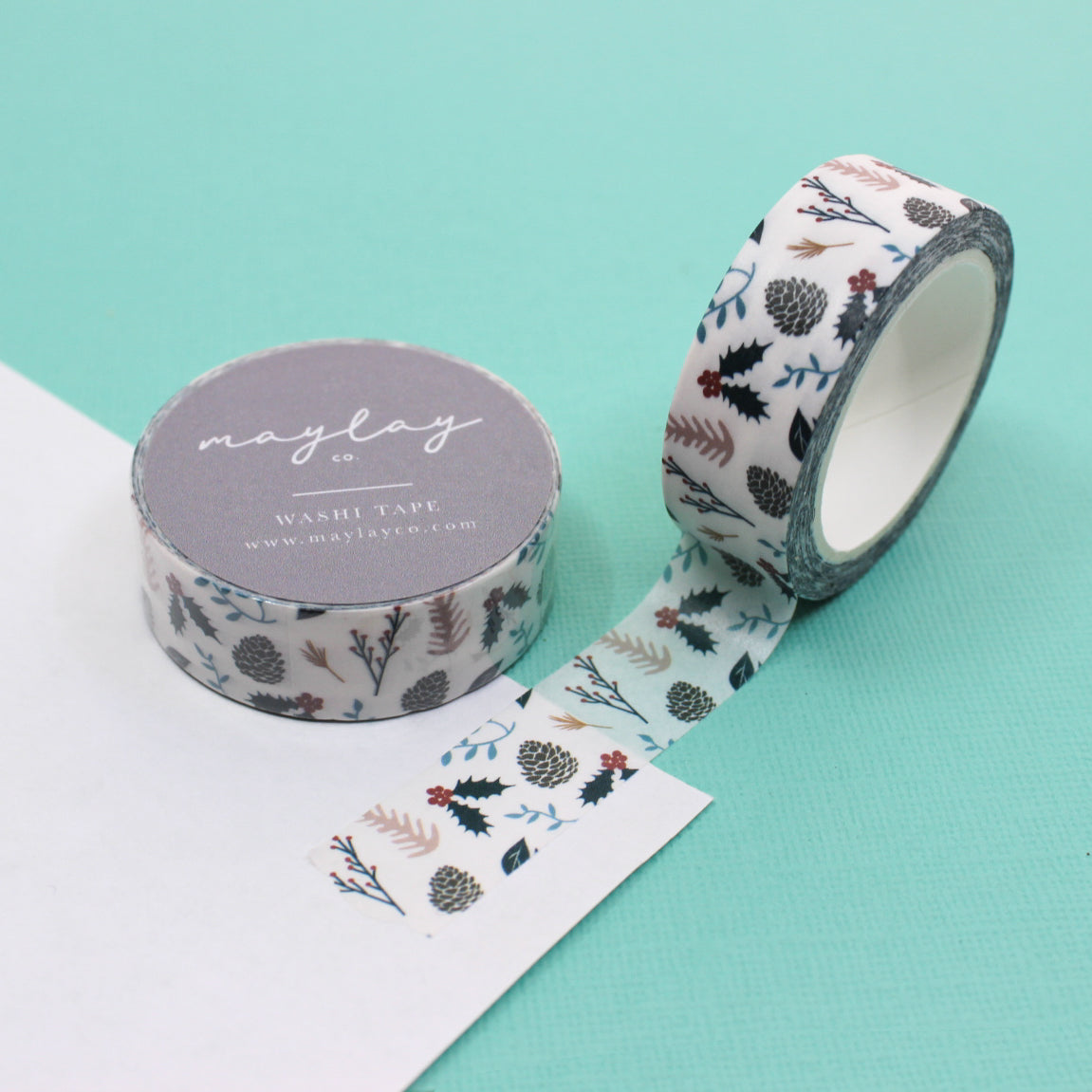 Holly & Pine Cones Winter Foil Washi Tape featuring elegant gold foil accents on a deep green background, adorned with festive holly and pine cone motifs, ideal for adding a touch of sophistication to your holiday crafting projects. This tape is from Maylay Co. and sold at BBB Supplies Craft Shop.