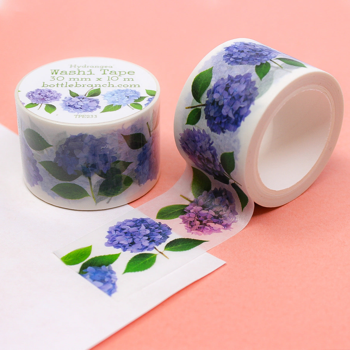 Hydrangea Floral Washi Tape features vibrant hydrangea blooms in various shades of blue, pink, and purple, set against a white background. Perfect for adding a floral touch to your crafts, this tape is ideal for scrapbooking, card making, or decorating journals. This tape is from Bottle Branch Designs and sold at BBB Supplies Craft Shop.