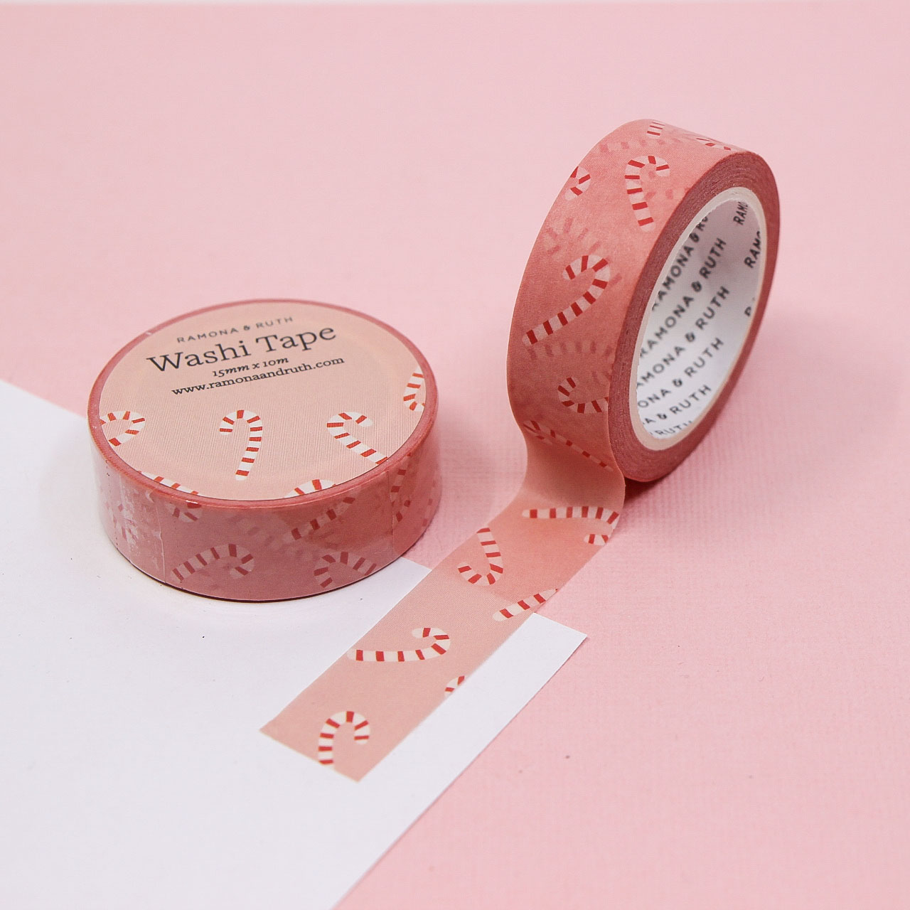 Festive washi tape featuring red and white candy canes on pink background