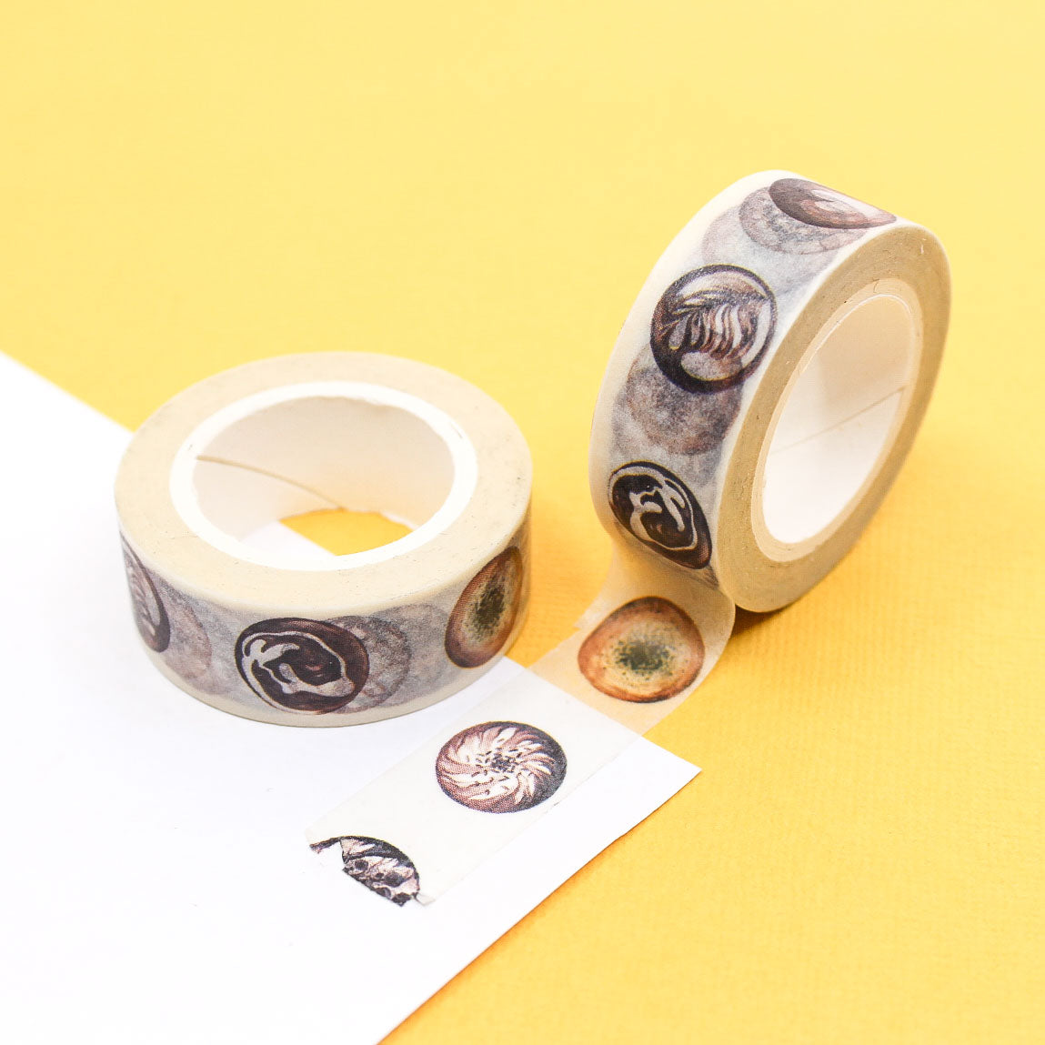 Coffee latte art washi tape roll with brown and cream circular drink designs on a white background.