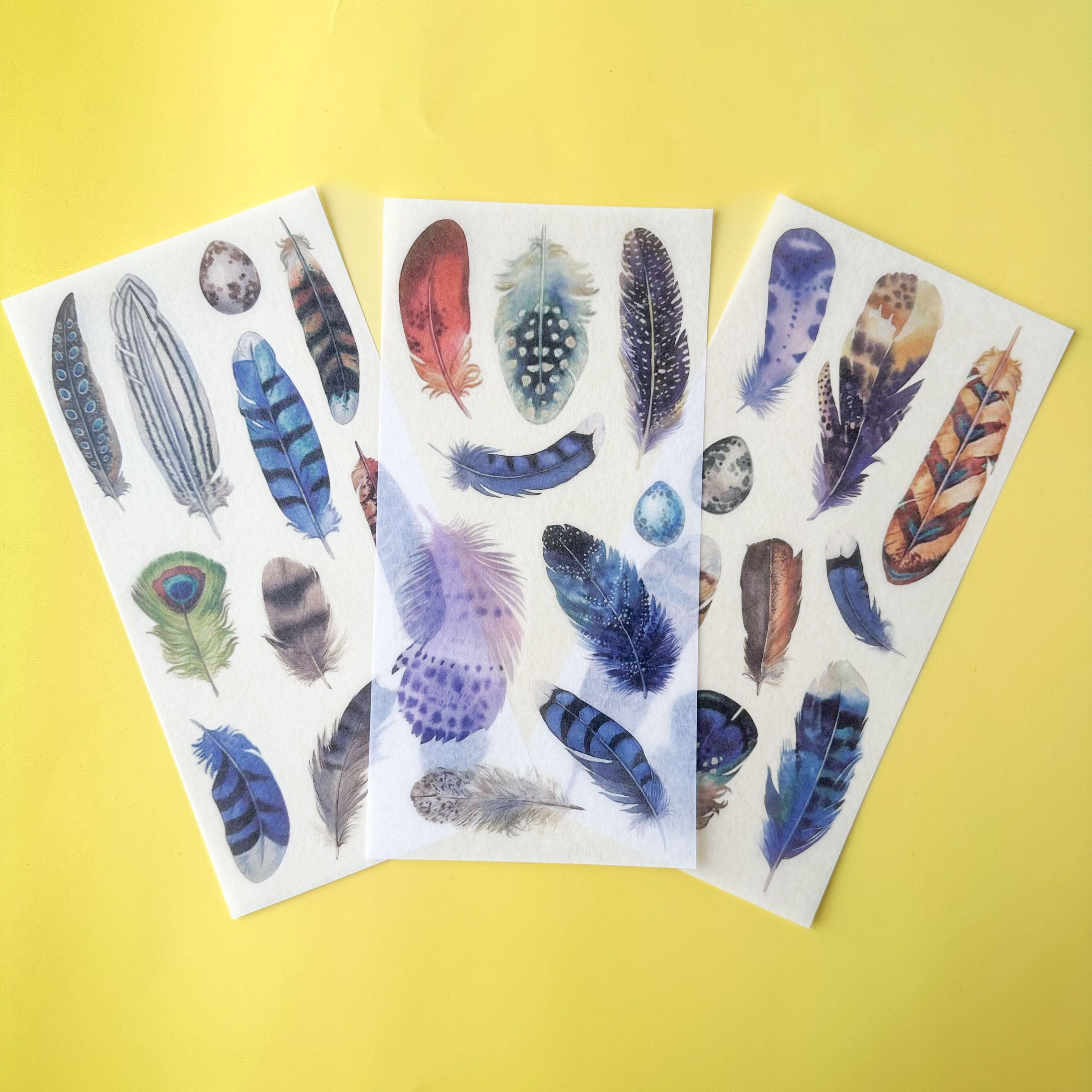 Three unique sheets of feather-themed stickers for your planner or journal on a yellow background