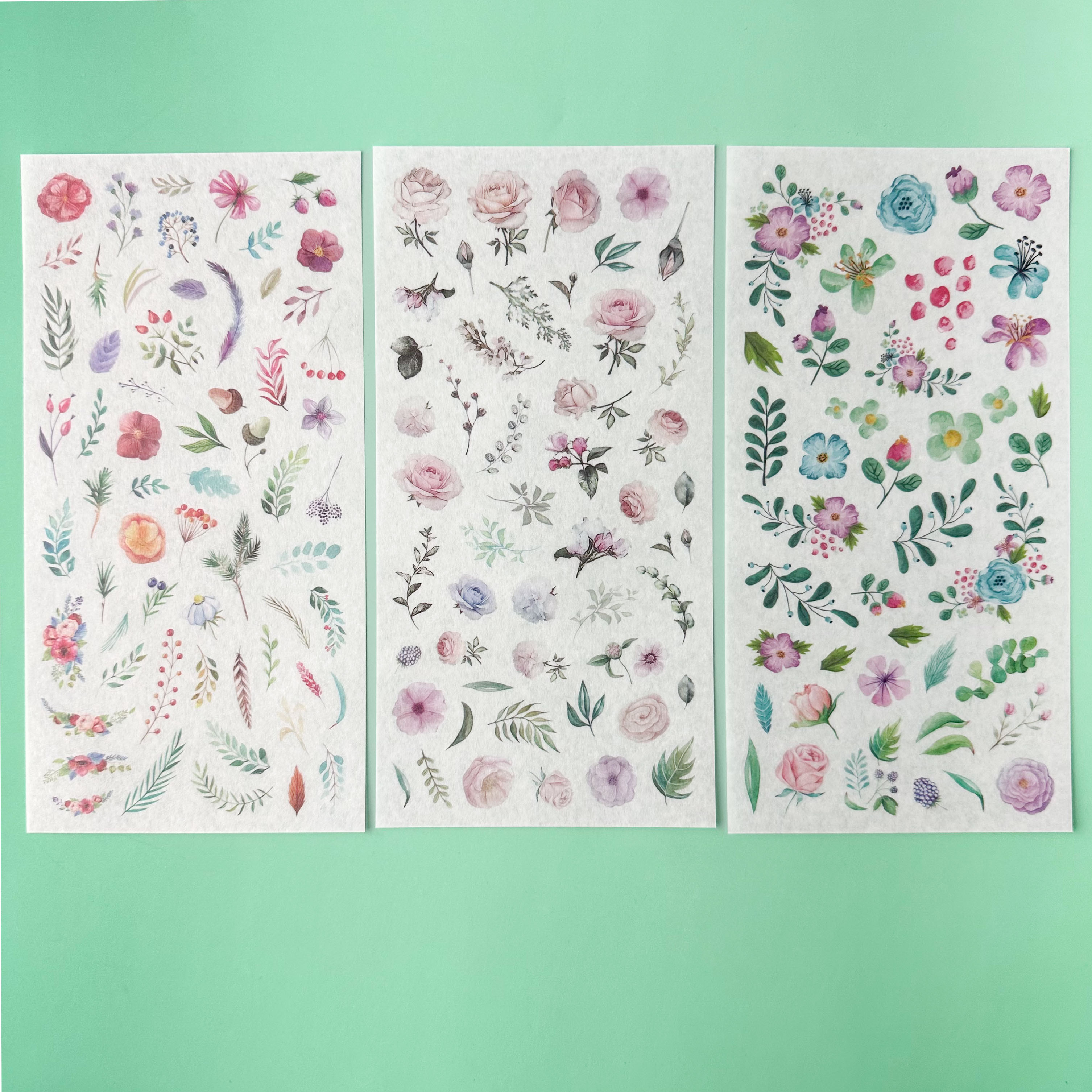 Colorful flower sticker sheets for planners and journals on a green background