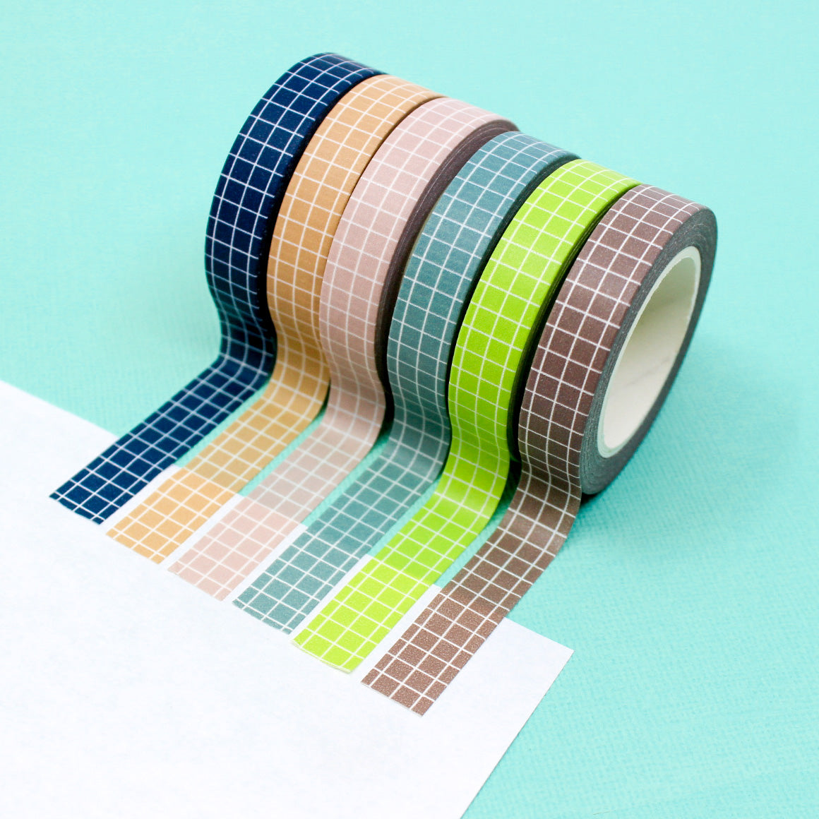 These colorful narrow grid tapes are functional and decorative, making them a must have for any planner, journal or calendar. These tapes come in Navy  Blue, Blue, Pink, Green, Brown, and peachy Tan and are sold at BBB Supplies Craft Shop.