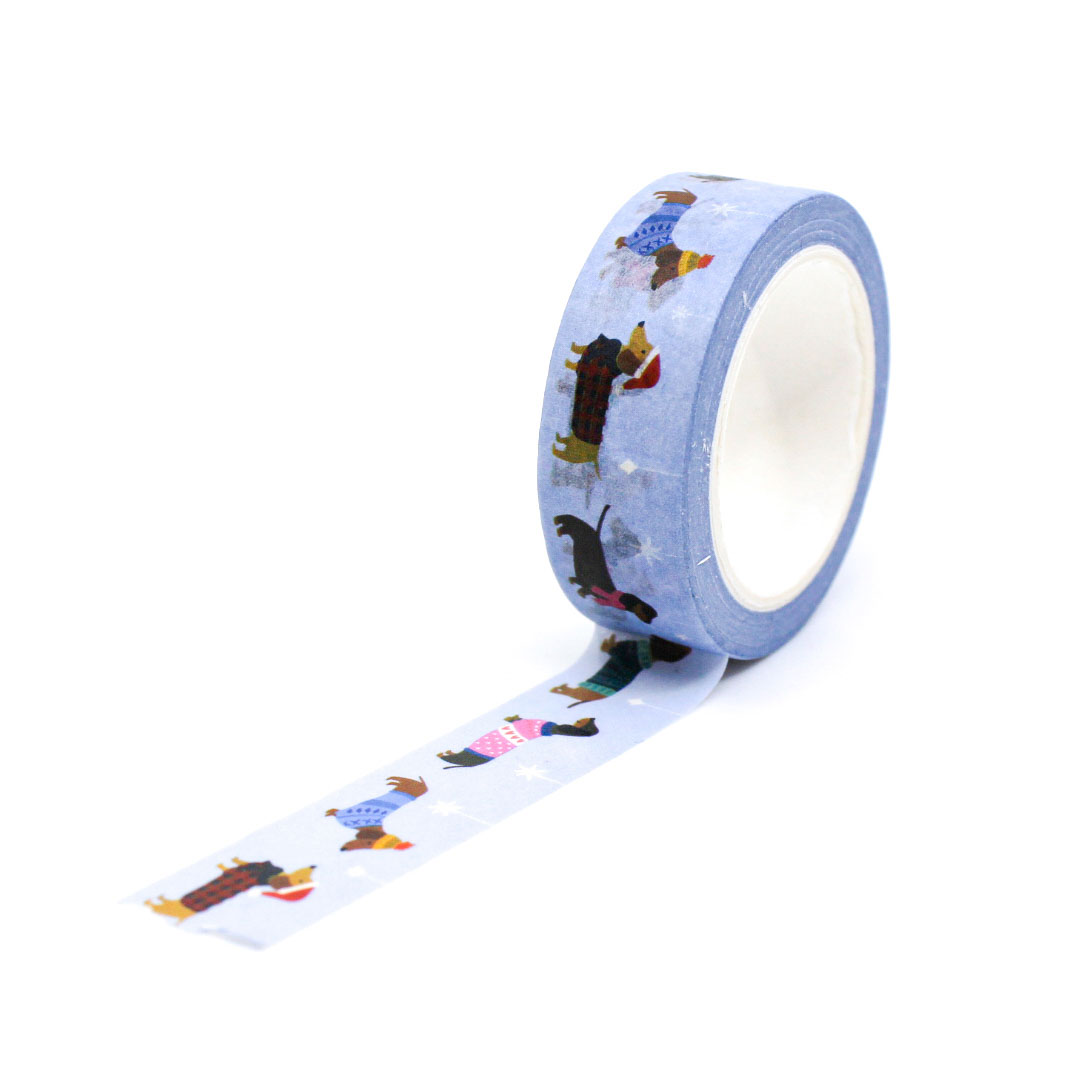 Festive dog washi tape unrolled on pink background — holiday stationery for journaling lovers.