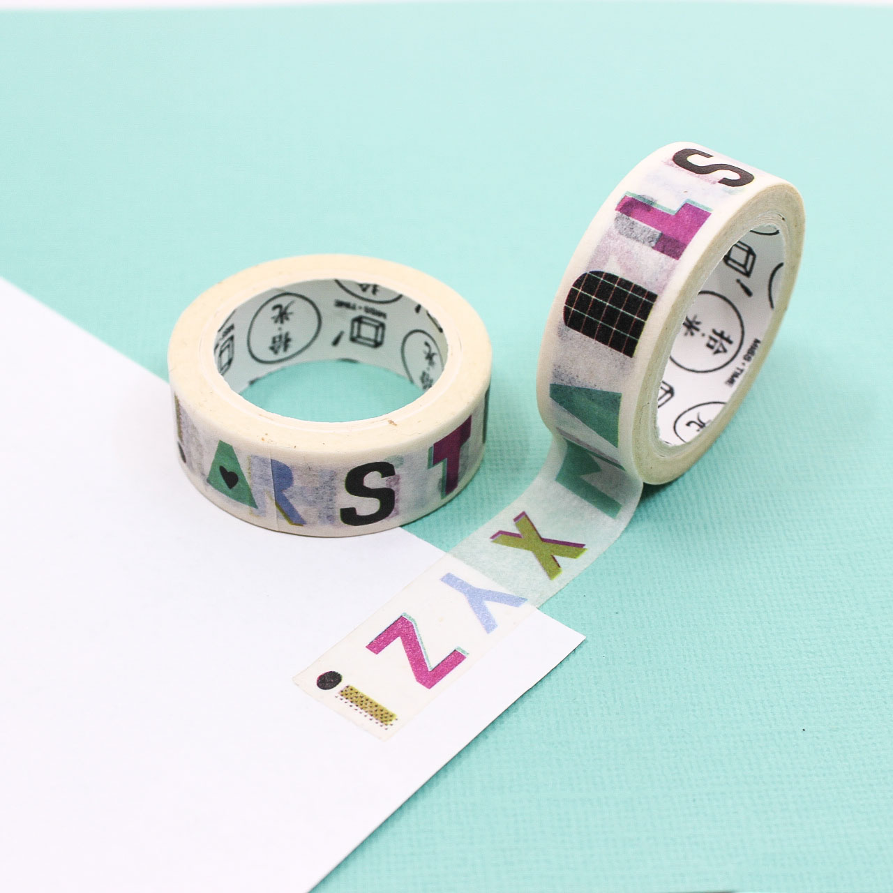 Bullet journal supply: rainbow alphabet washi tape roll displayed with box.