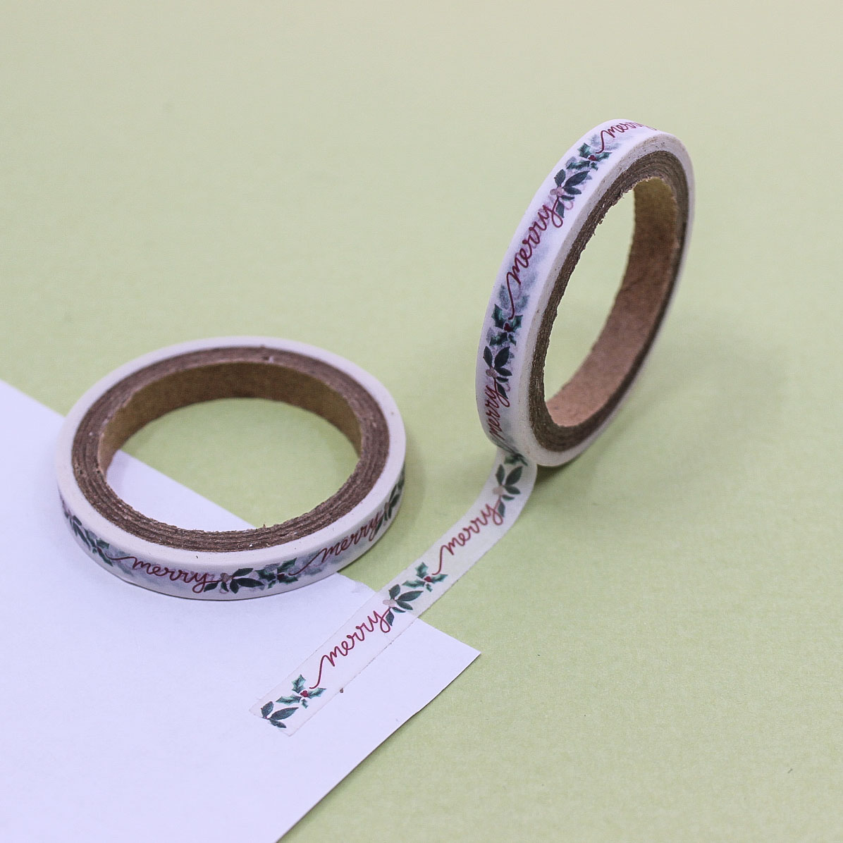 Close-up of Christmas themed washi tape featuring handwritten lettering and greenery.