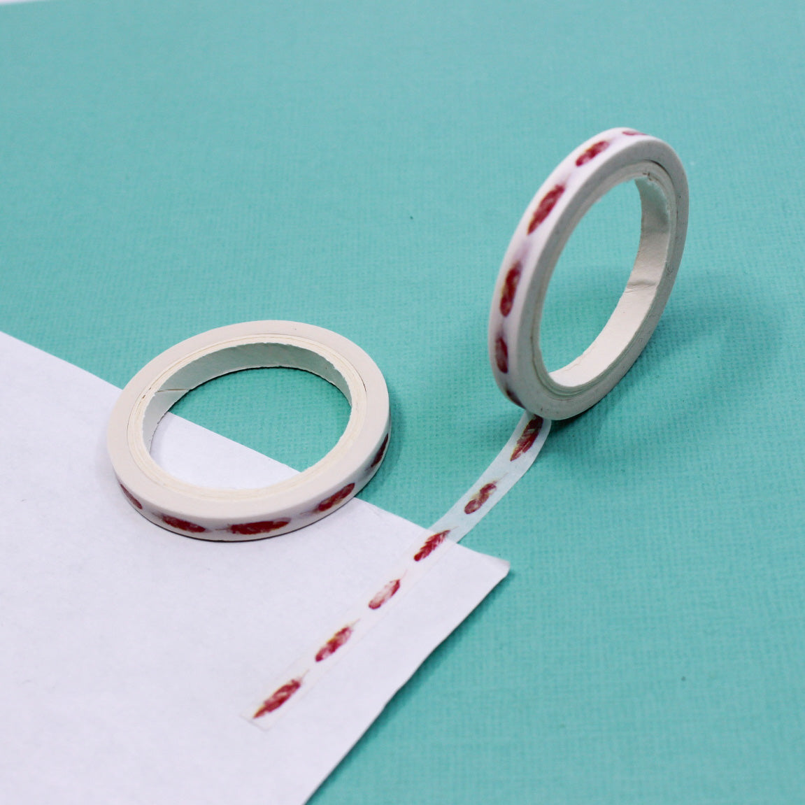 Decorative feather washi tape being used to accent a journal page.