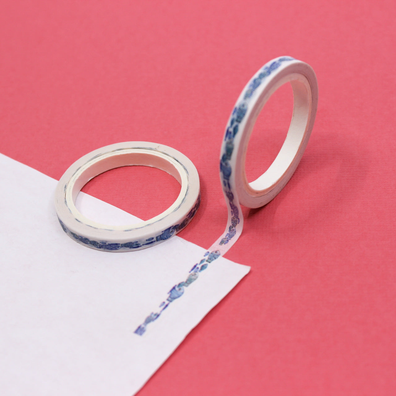 Close-up of watercolor fish illustrations on aesthetic washi tape with packaging beside it.