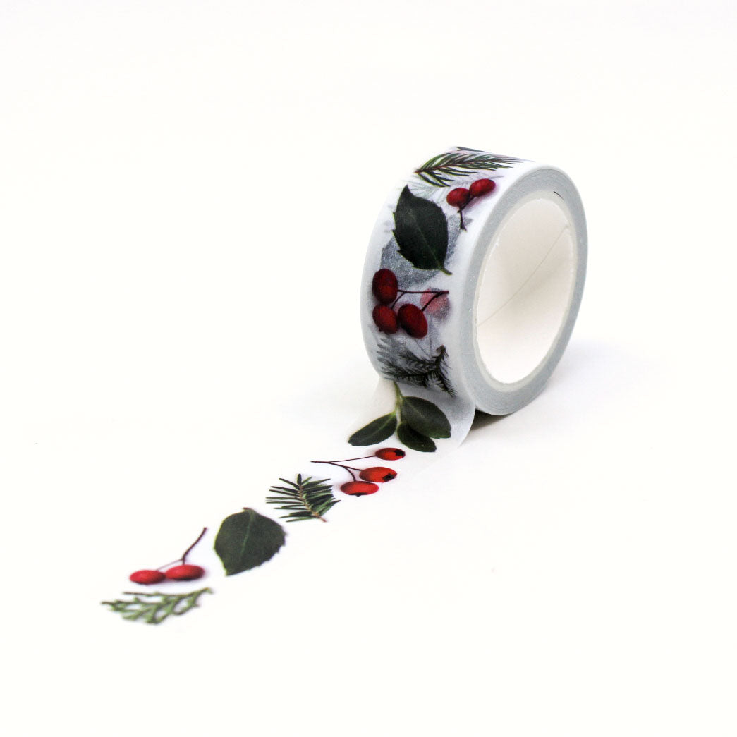 Holiday-inspired botanical washi tape with green evergreen branches and red berries.
