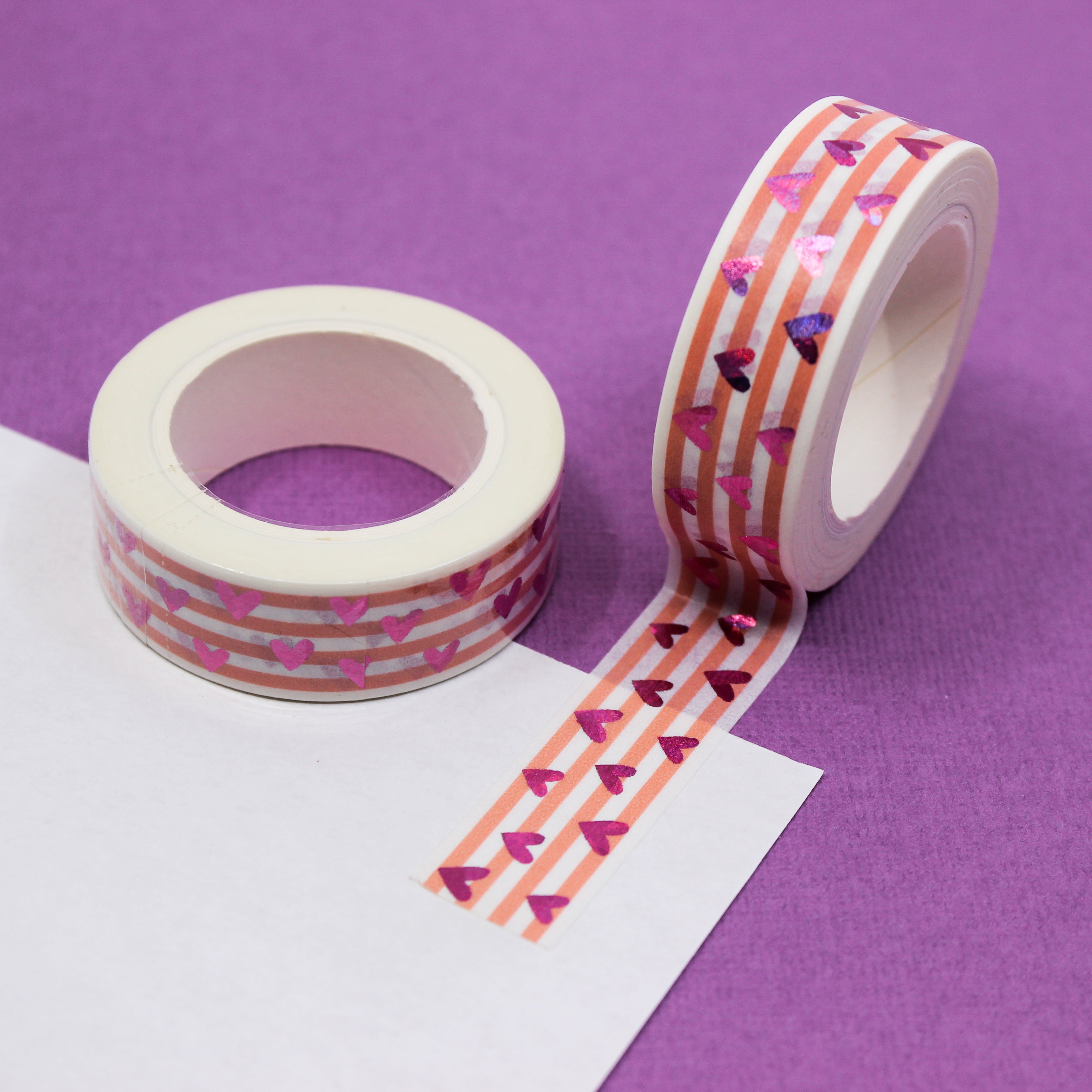 This vibrant pink foil heart washi tape features a narrow pink stripe as a backdrop making it a colorful but elegant choice for your valentines spreads, craft projects, and BUJO layouts. This tape is sold at BBB Supplies craft shop.