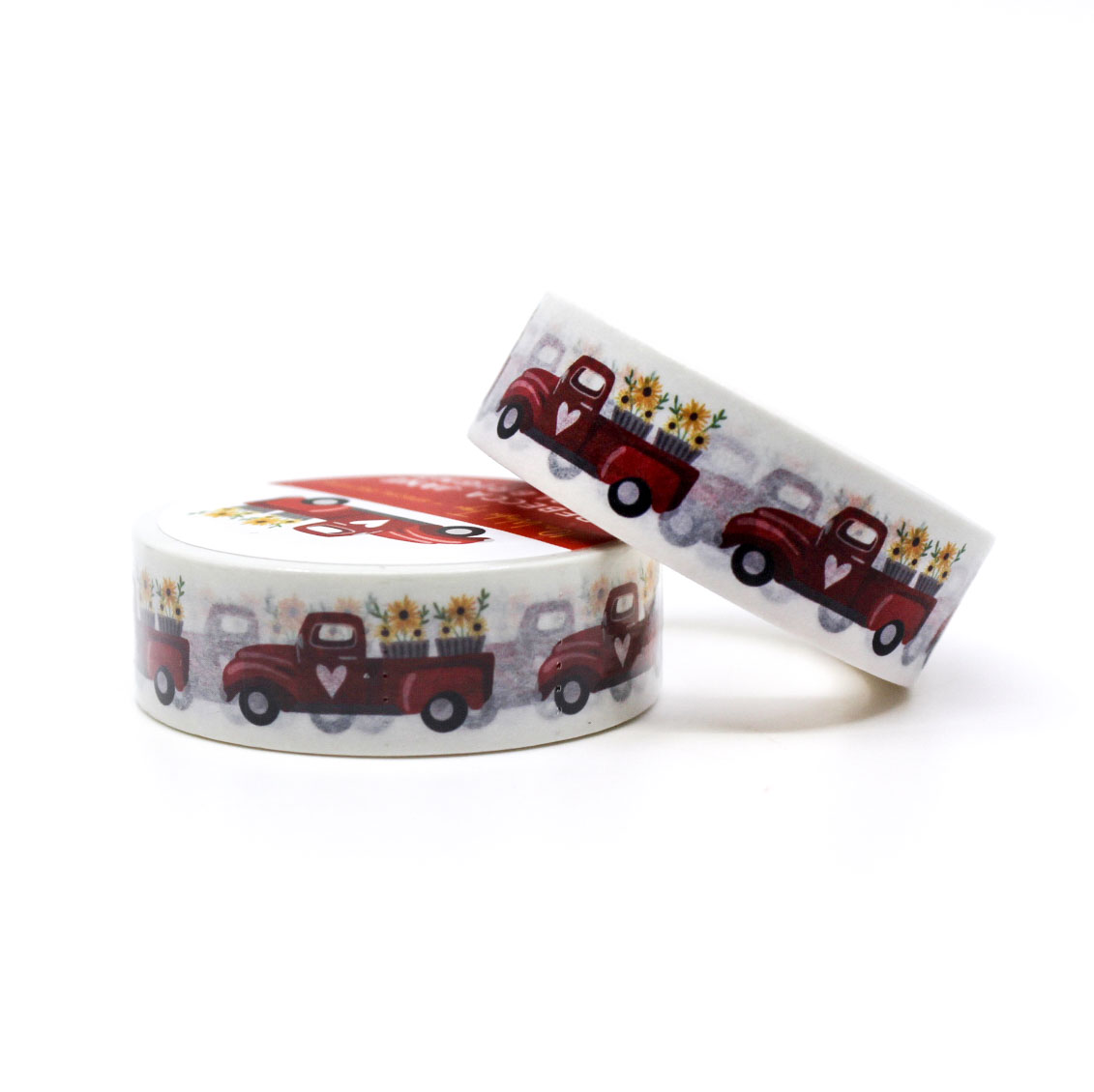 Two rolls of decorative tape with red truck designs on a white background