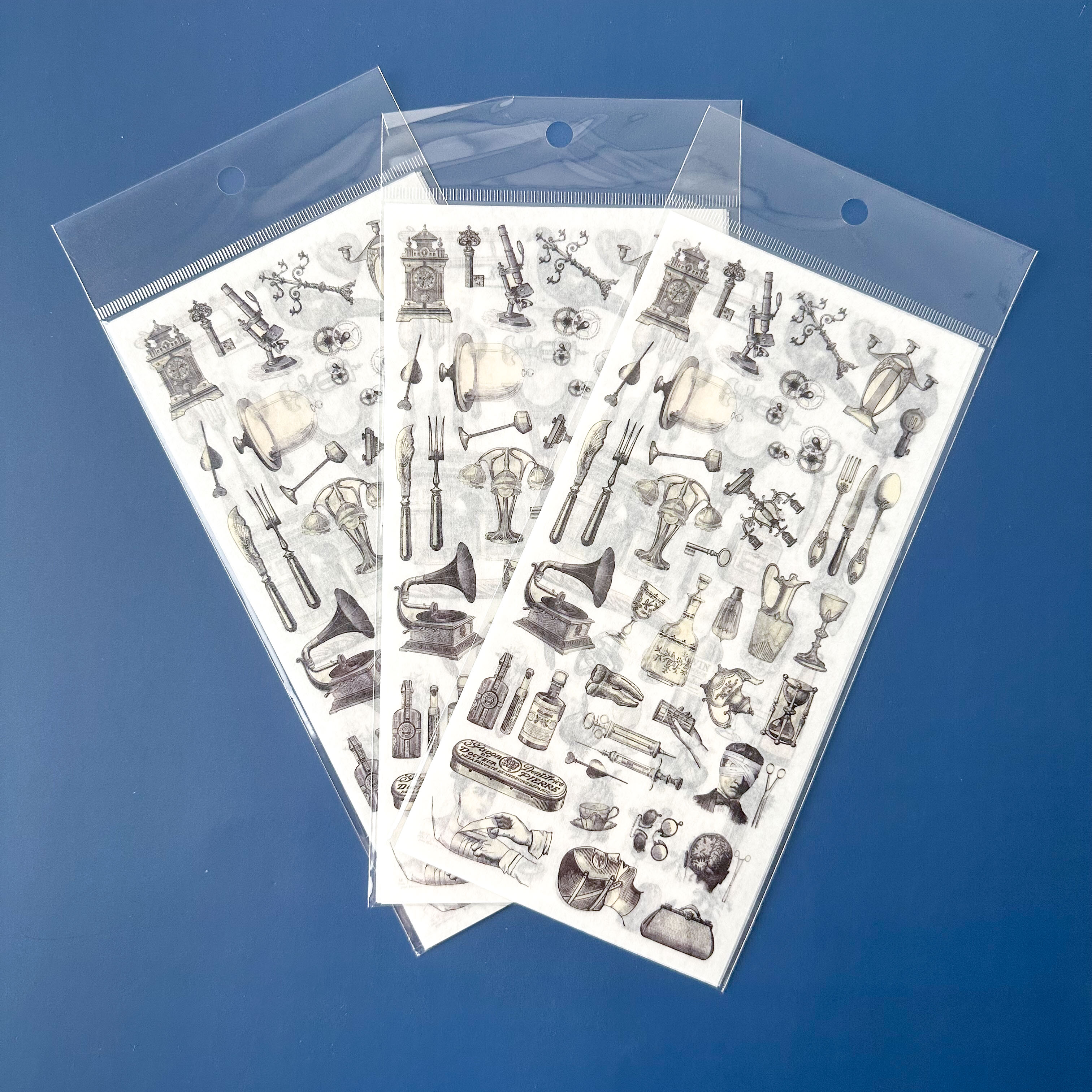 Three sheets of Black and white vintage decorative stickers with vintage-style illustrations on a blue background.