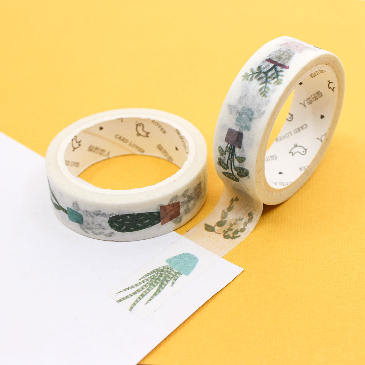 Washi tape roll featuring watercolor houseplants and succulents on a yellow background.