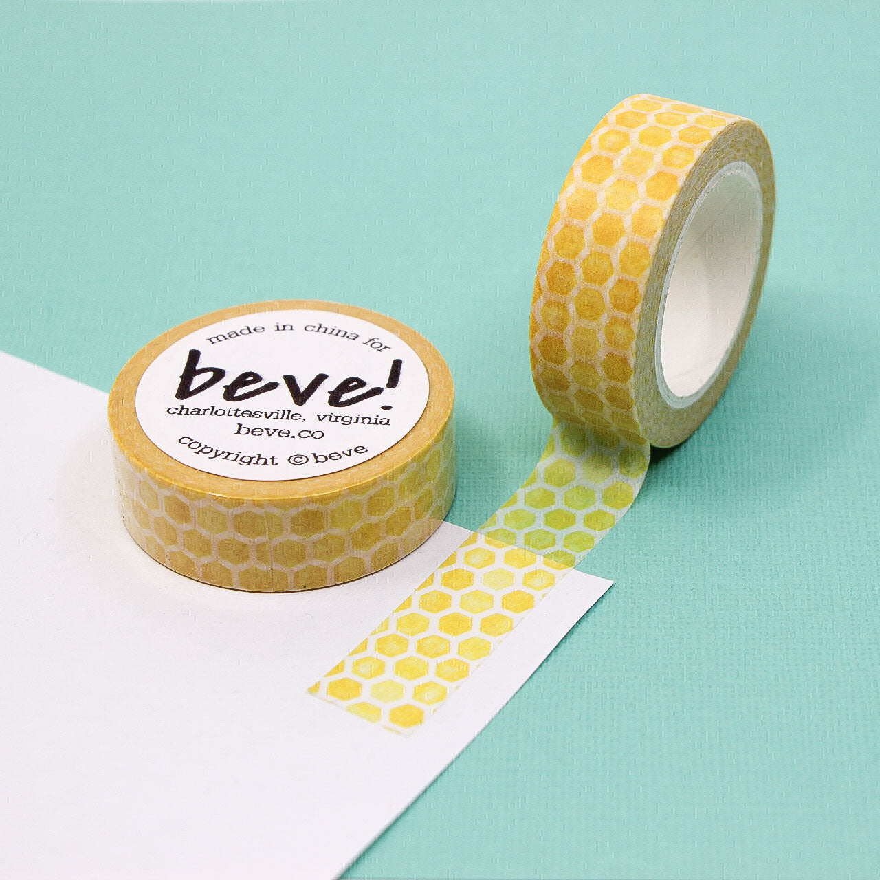 Yellow honeycomb hexagon pattern washi tape roll on white background.